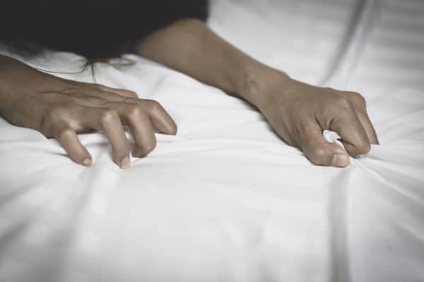 Rape & Sexual Assault Defense 13 A woman's hands grabbing on the bed sheets as though she is being sexually assaulted.