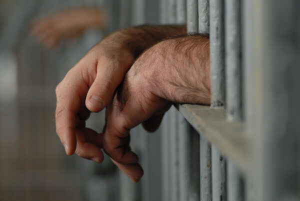 Rape & Sexual Assault Defense 4 A man's hands hanging outside prison cell bars